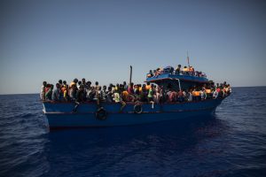 Migrants wait to be rescued by the Aquarius rescue ship run by non-governmental organisations (NGO) "SOS Mediterranee" and "Medecins Sans Frontieres" (Doctors Without Borders) in the Mediterranean Sea, 30 nautic miles from the Libyan coast, on August 2, 2017. Italy on August 2, 2017 began enforcing a controversial code of conduct for charity boats rescuing migrants in the Mediterranean as new figures revealed a sharp drop in the numbers of people arriving from Libya. / AFP PHOTO / Angelos Tzortzinis